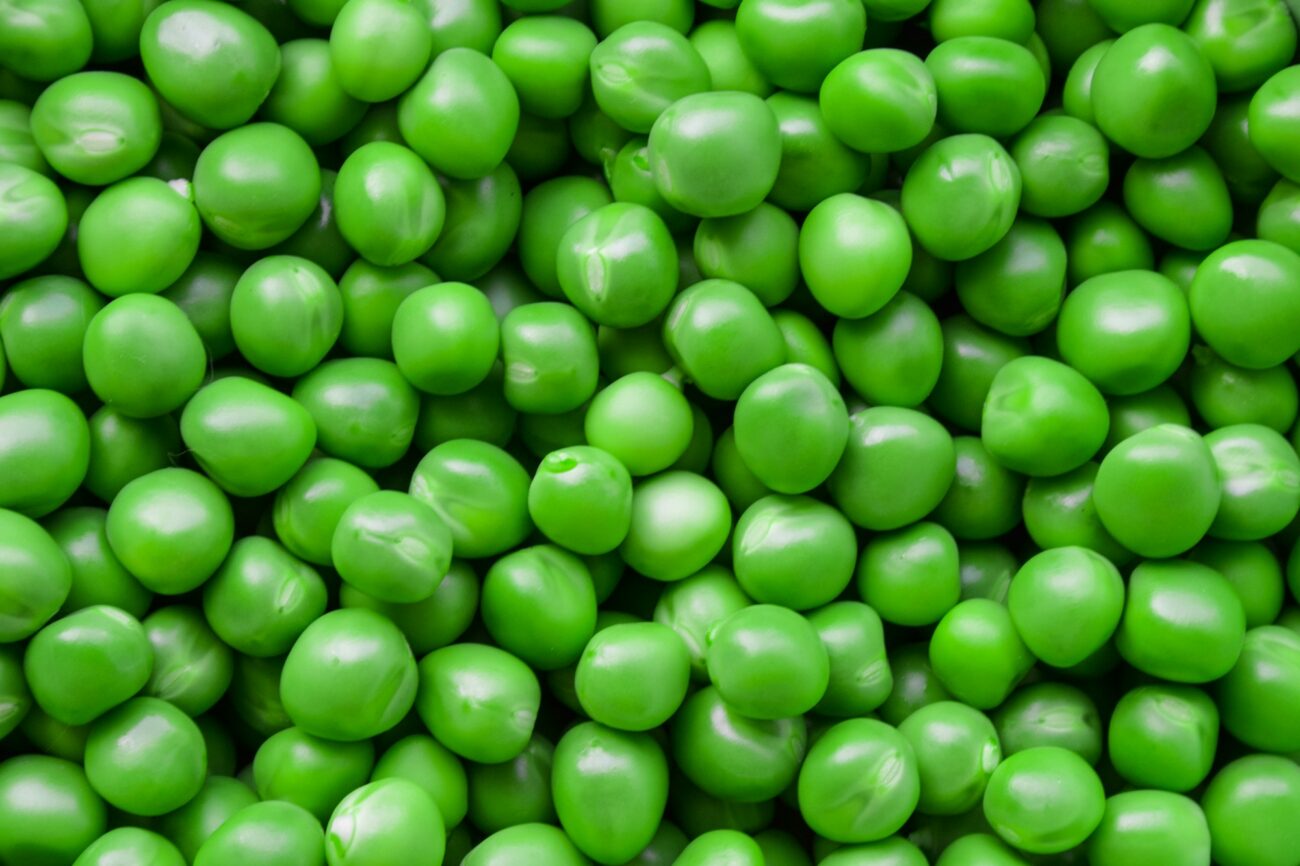 A heap of shelled green peas filling the frame